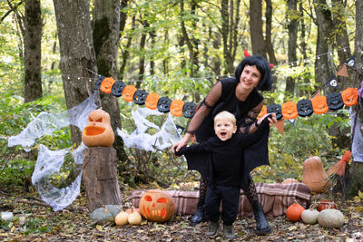 Halloween. mother with little son in halloween costumes having fun outdoor