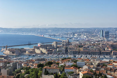 High angle view of buildings by sea against sky