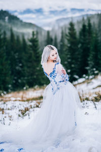 Woman standing on snow covered land