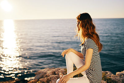 Woman looking at sea against sky