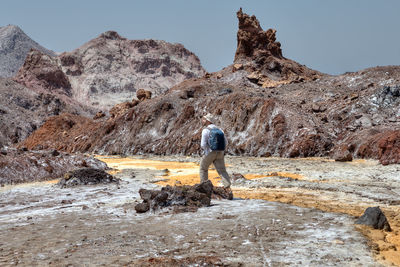 Man walking against rock formations