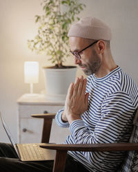 Side view of man talking on video call at home