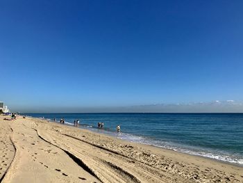 Scenic view of beach against clear blue sky