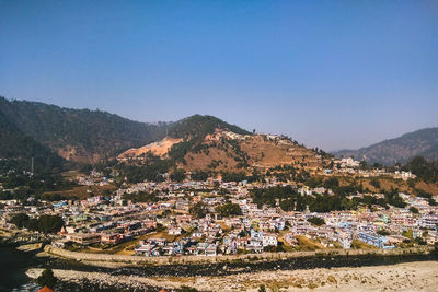 High angle view of townscape and mountains against clear sky