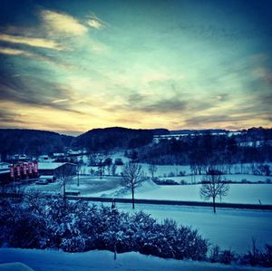 Scenic view of snow covered mountains against sky at sunset