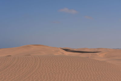 Sand dunes in desert against sky