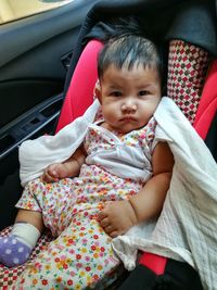 Portrait of cute baby girl in car