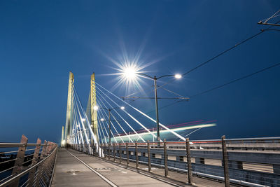 Low angle view of illuminated bridge against sky