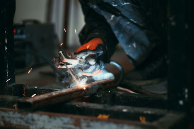 Low section of worker welding metal in workshop