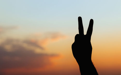 Silhouette person against orange sky during sunset