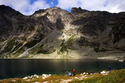 People enjoying in lake against mountains