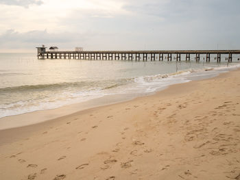 The sandy beach of the sea has wind waves, there are stone bridges that walk in the sea