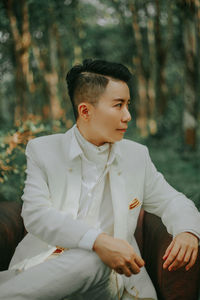Young man sitting in forest