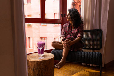 Woman drinking glass on table at home