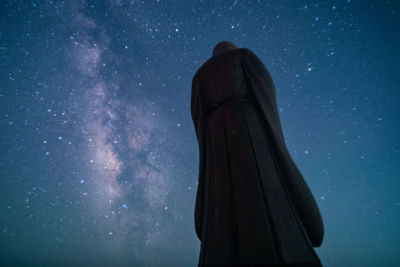 Rear view of woman standing against star field