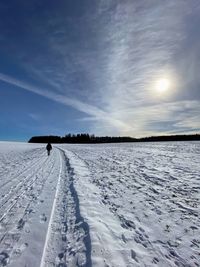 Scenic view of snow covered field against sky