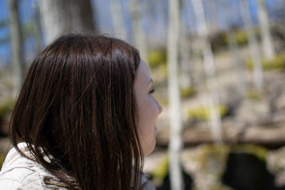 Side view of thoughtful young woman looking away in forest