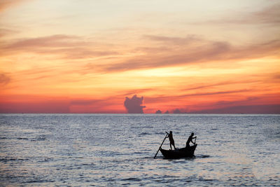 Silhouette boat in sea against sky during sunset