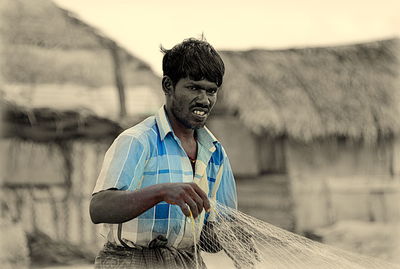 Man holding umbrella standing on field