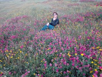 Full length of woman with pink flowers on field