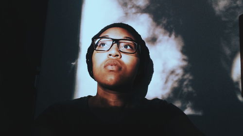 Low angle view of woman against wall with shadow