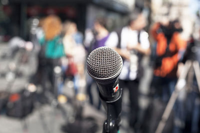 Close-up of microphone against people