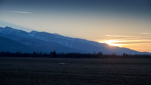 Scenic view of snowcapped mountains against sky during sunset