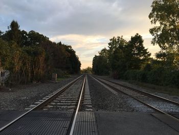 Railroad track against cloudy sky