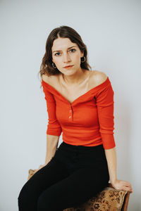 Portrait of young woman against white background