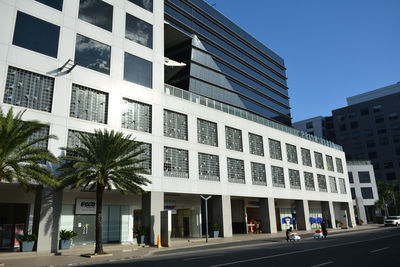 Road by building in city against sky