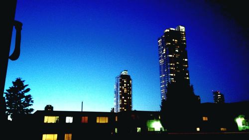 Low angle view of modern building against clear sky at dusk