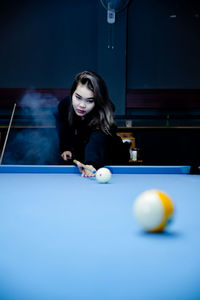 Young woman playing pool