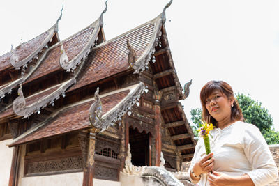 Portrait of woman against building