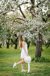 Portrait of a beautiful young girl in a blooming apple orchard in spring