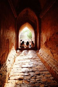 Rear view of people in corridor of historic building