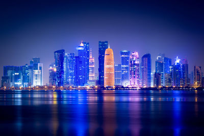 Illuminated buildings against sky at night