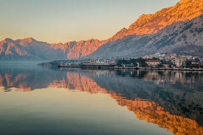 Scenic view of lake and mountains against sky during sunset