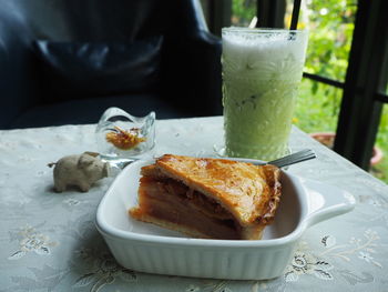 Close-up of apple pie and ice green tea on the table