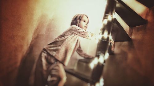 Woman looking away while sitting on floor