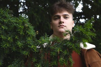 Portrait of young man against plants