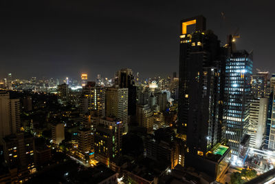 Illuminated buildings in city against sky at night