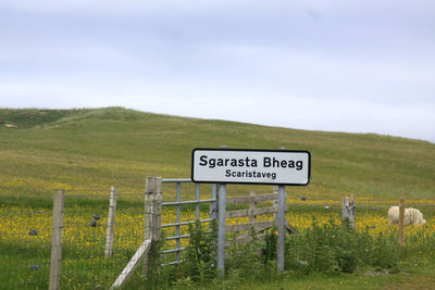 Information sign on landscape against sky