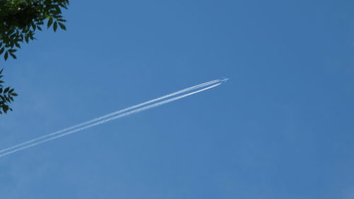 Low angle view of vapor trail against blue sky