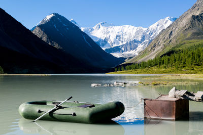 Scenic view of lake by snowcapped mountains against sky