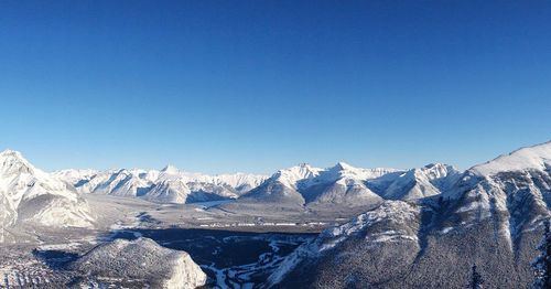 Scenic view of snowcapped mountains against clear blue sky