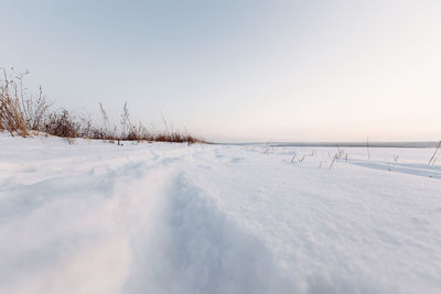 Scenic view of snow covered land against sky