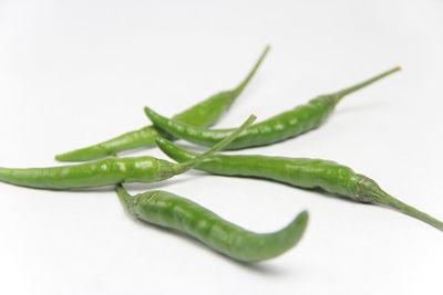 Close-up of green chili pepper against white background
