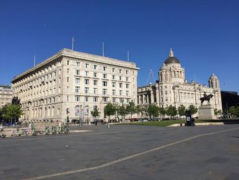 Buildings in city against clear blue sky