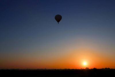 Silhouette hot air balloon against clear sky