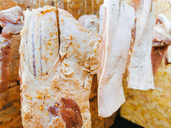 Raw pork meat seasoned and hanged for the smoking process